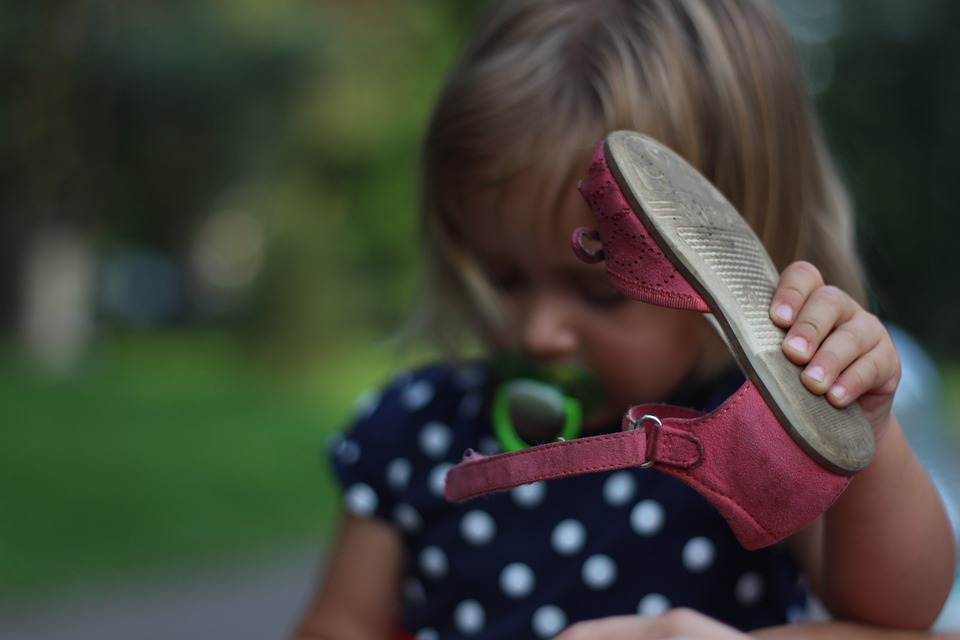 Meisje met schoen in hand